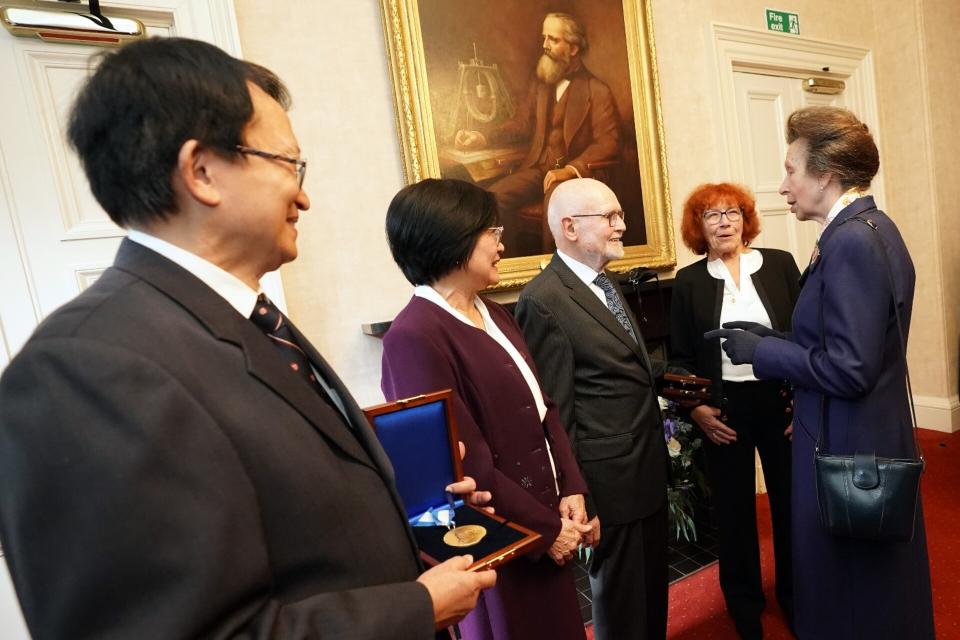 Princess Anne in conversation with Prof. Wolff under the picture of the award's namesake: James Clerk Maxwell, after the award ceremony. On the left in the picture: Prof. Chang (recipient 2023) and his wife, on the right Hannelore Bolkenius.